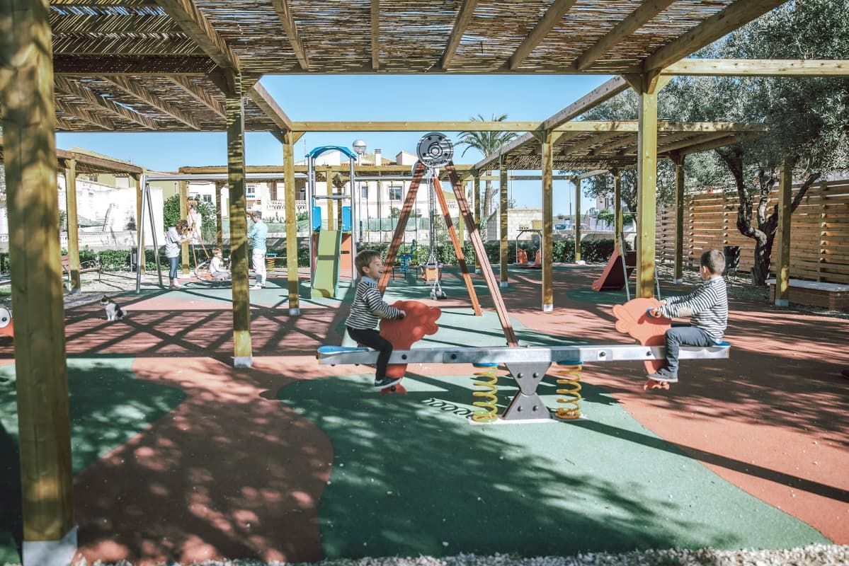 Un grupo de niños está jugando en un balancín en un patio de recreo.