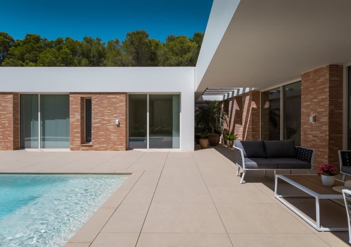 Hay una piscina en el patio trasero de una casa.