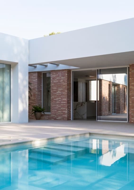 Una casa con una gran piscina delante de ella.