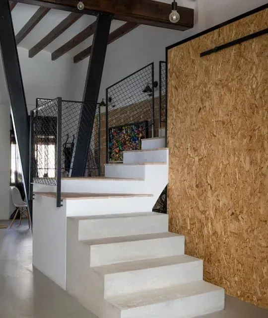 Una escalera con una pared de madera detrás.