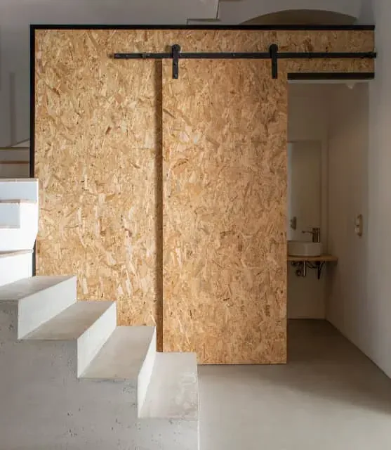 Una habitación con una puerta corrediza de granero y escaleras.