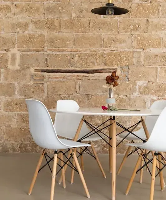 Una mesa y sillas frente a una pared de ladrillos