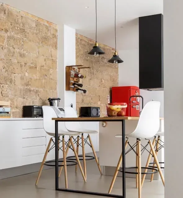 Una cocina con una mesa y sillas y un refrigerador rojo.