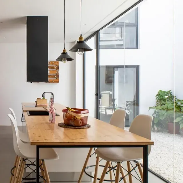 Una cocina con mesa y sillas y una gran ventana.