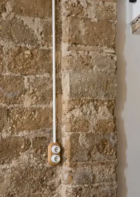 Una pared de ladrillos con un interruptor de luz.