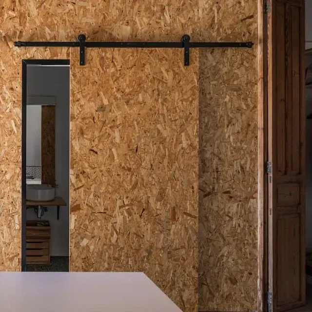 Una puerta corrediza de granero que conduce a un baño con lavabo.