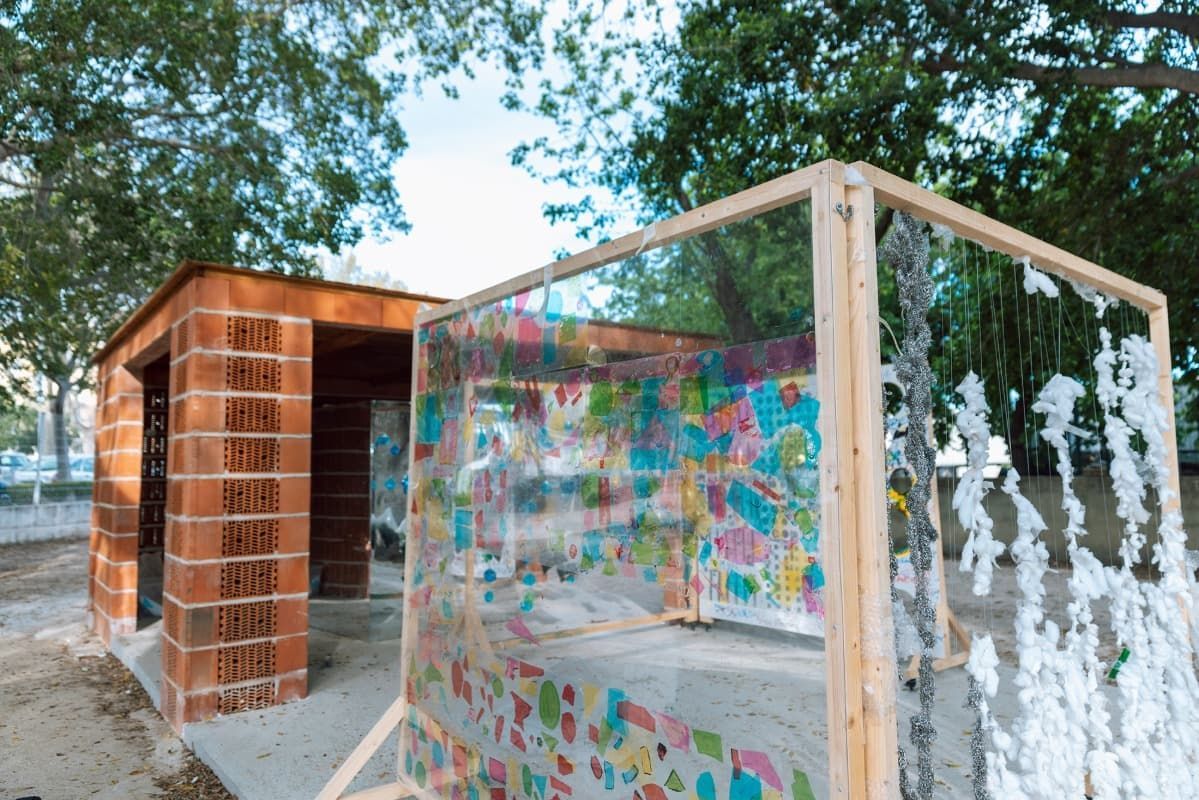 Un edificio de ladrillo con una valla de plástico transparente a su alrededor.