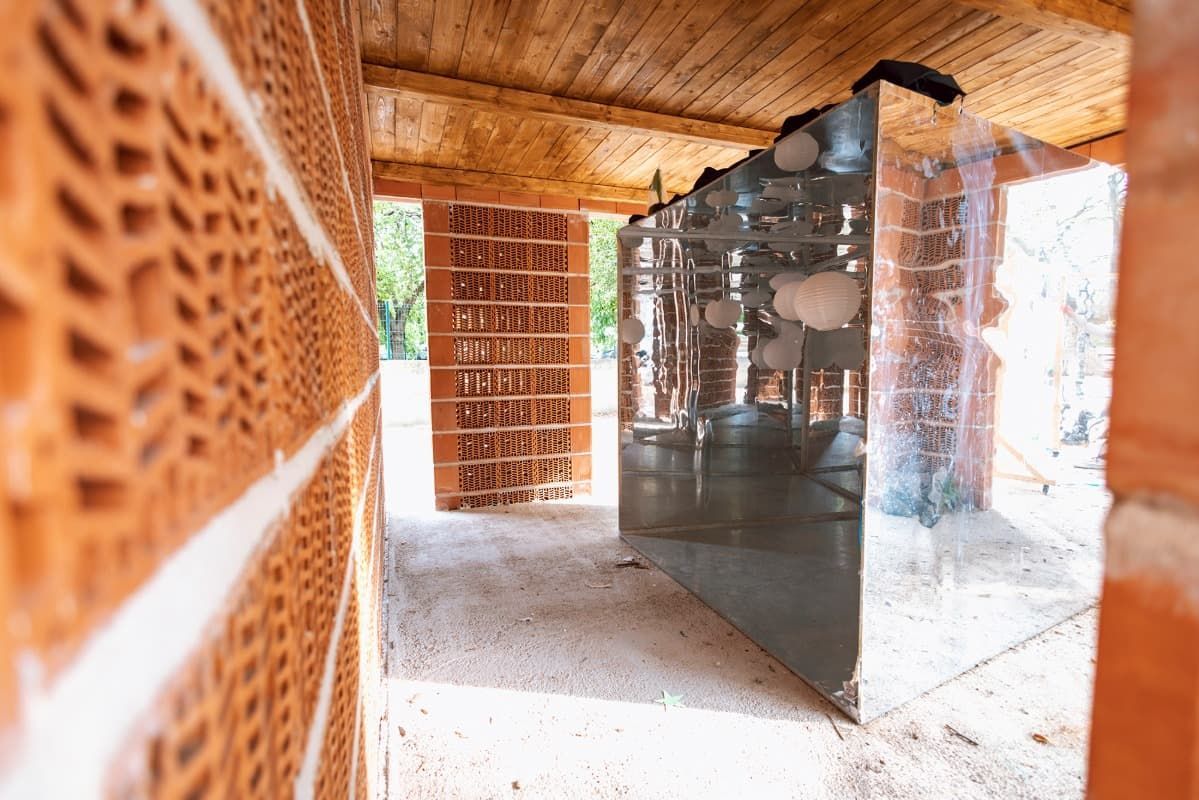 Una pared de ladrillos con un espejo en el medio.