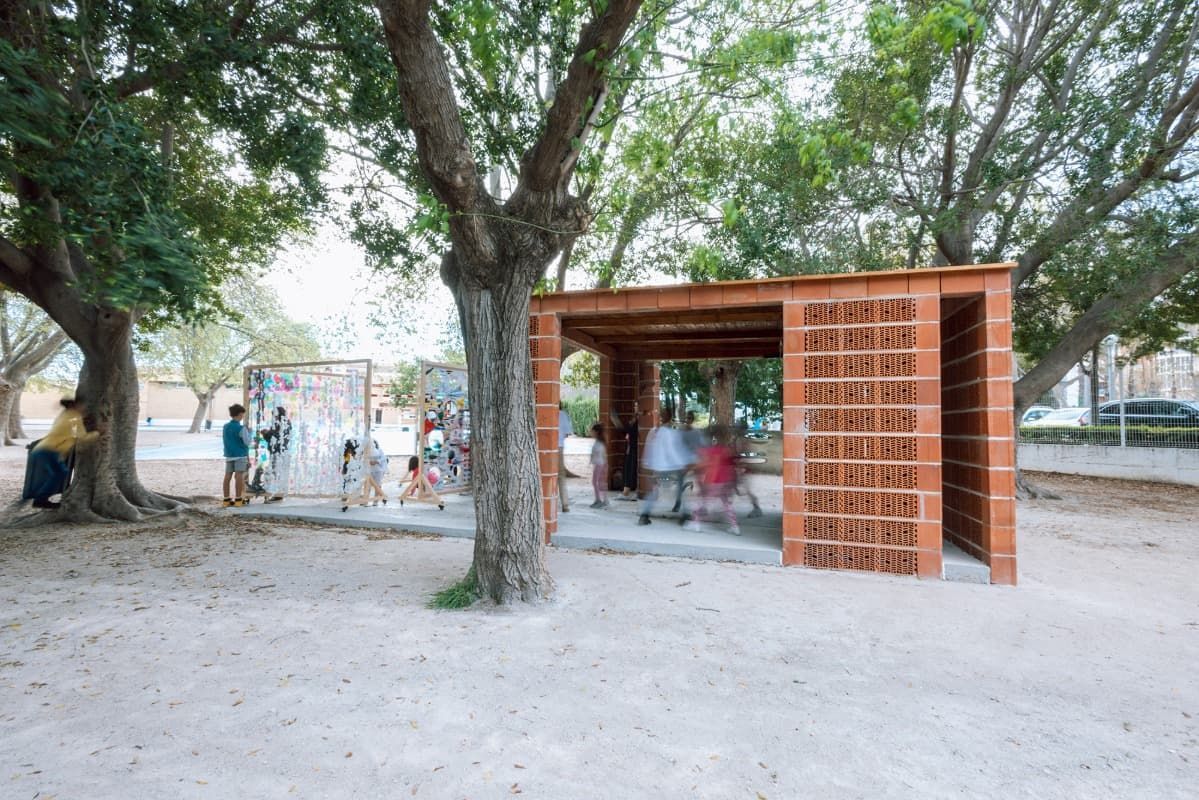 Un grupo de personas está de pie debajo de una estructura de ladrillos en un parque.