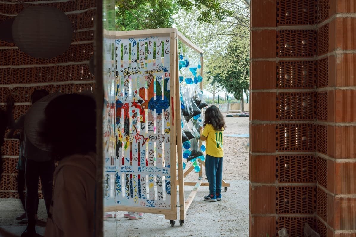 Una niña está parada frente a una exhibición de botellas.