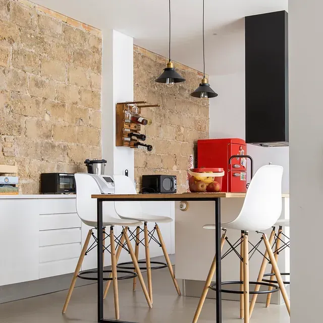 Una cocina con una mesa y sillas y un refrigerador rojo.