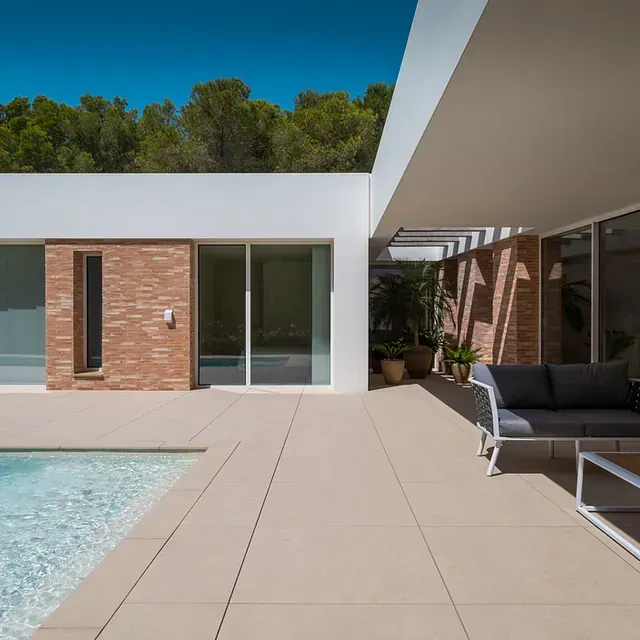 Una casa con piscina y un sofá delante.