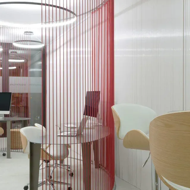 Una habitación con un escritorio y sillas y una computadora encima.