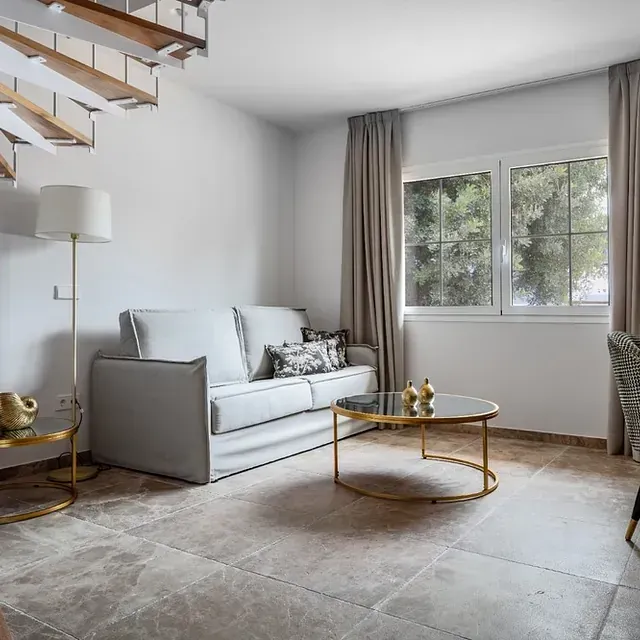 Hay un sofá y una mesa de café en la sala de estar.