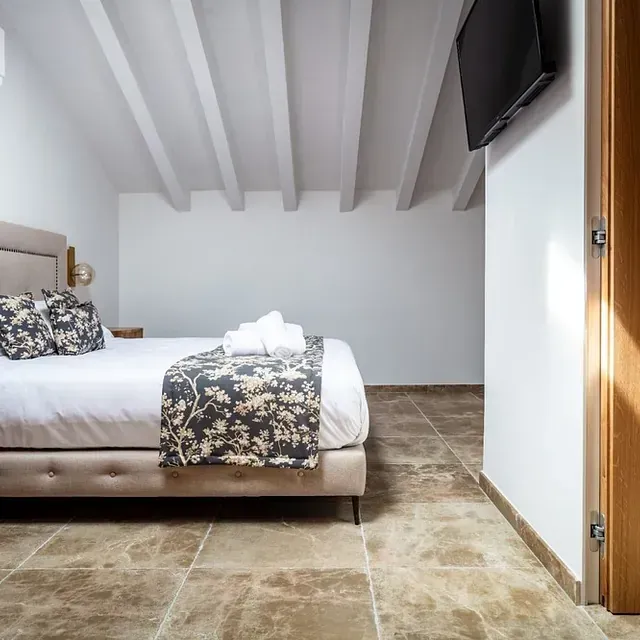 Un dormitorio con una cama grande y un televisor de pantalla plana.