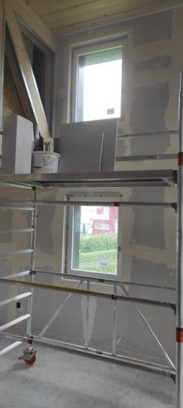 Innenansicht eines im Bau befindlichen Gebäudes, mit einem Gerüst um zwei Fenster.