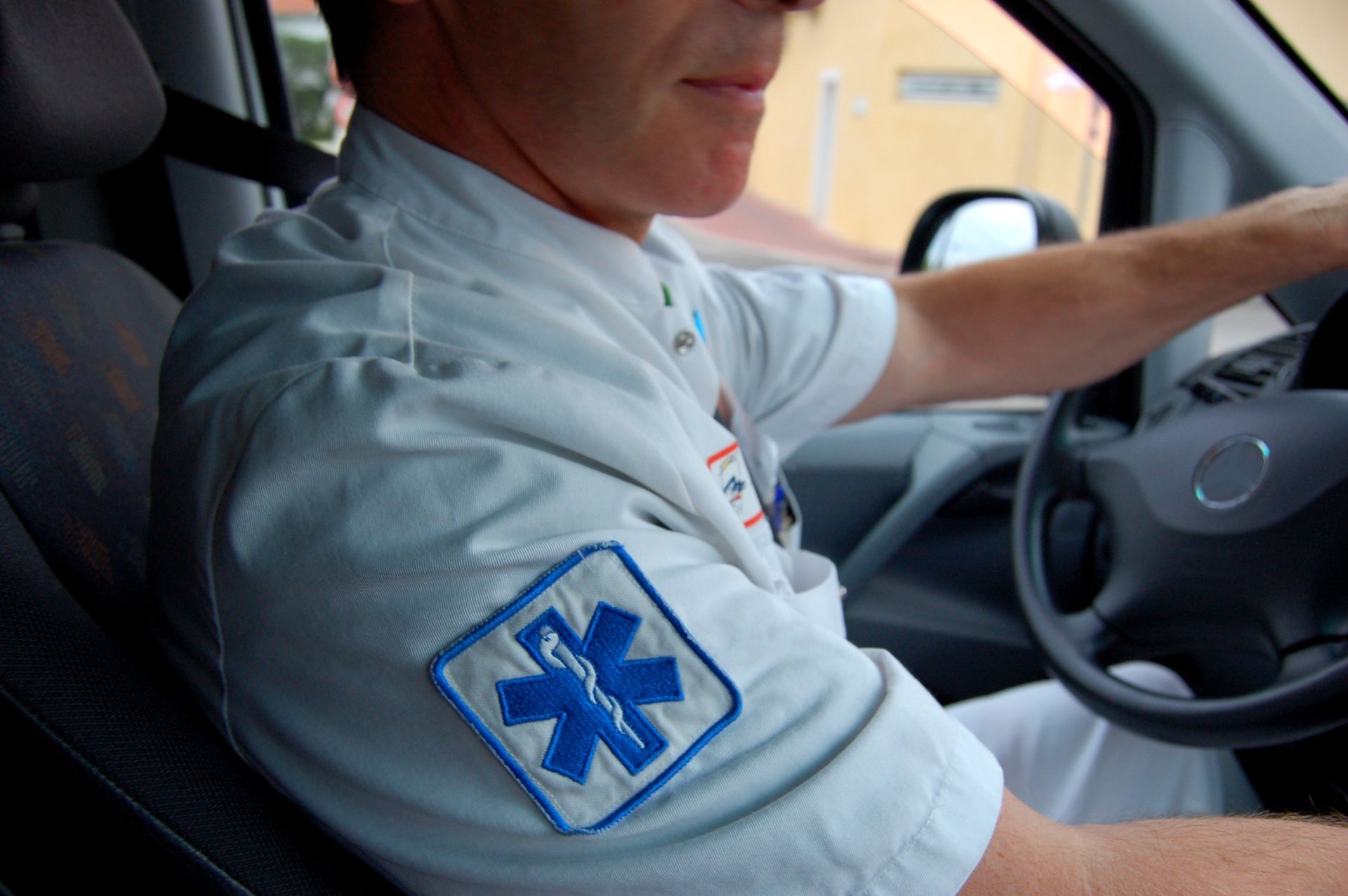 Un ambulancier conduit un véhicule.