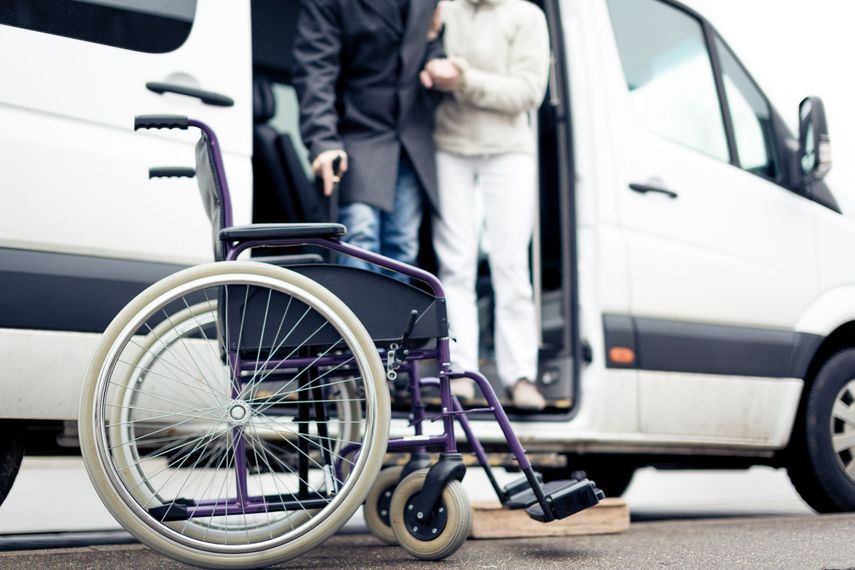 Un fauteuil roulant est garé à côté d'un véhicule sanitaire.