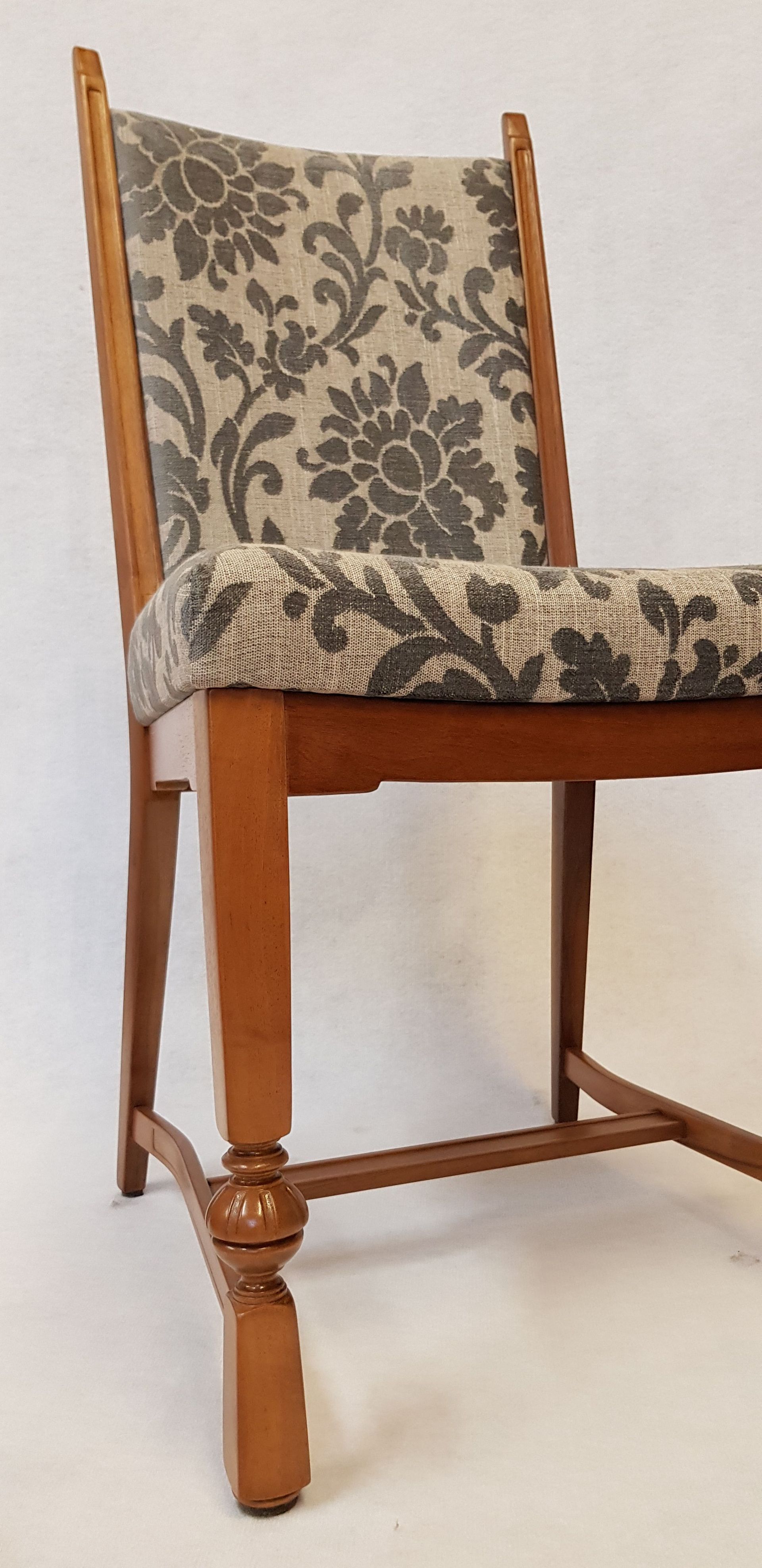 Ein Holzstuhl mit einem Sitzkissen mit Blumenmuster