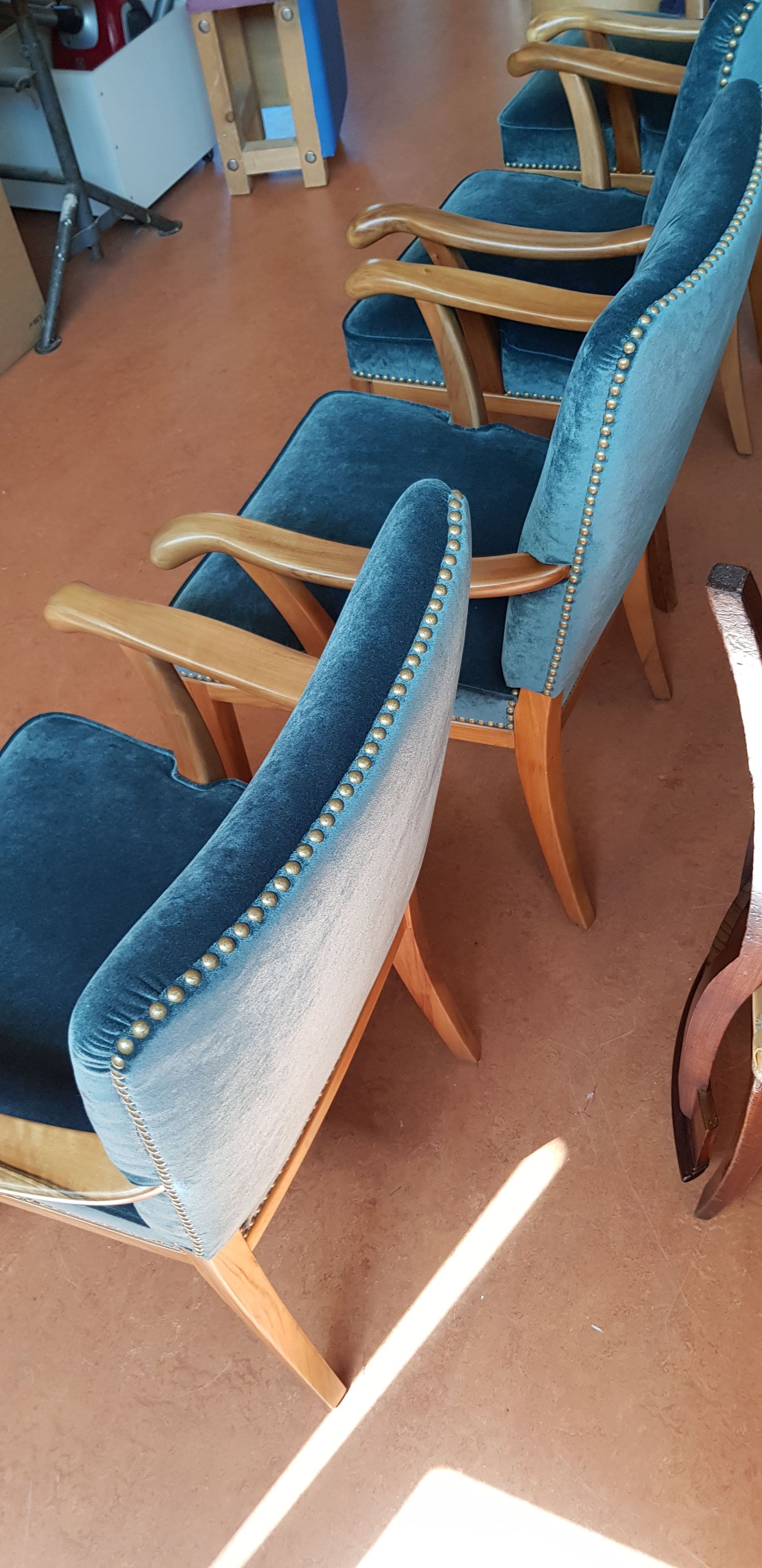 Eine Reihe blauer Stühle steht auf einem Holzboden.