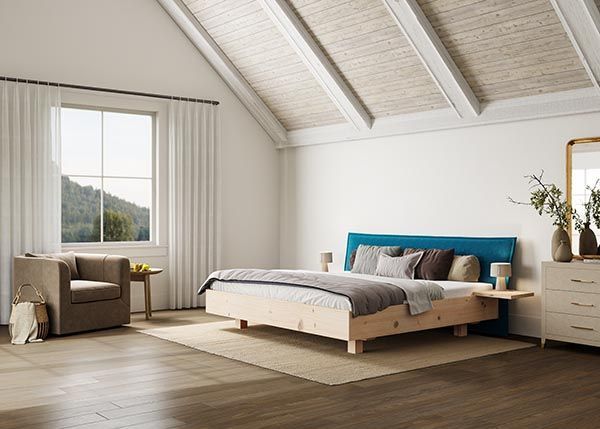 Ein Schlafzimmer mit Bett, Stuhl, Kommode und Spiegel.