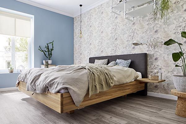 Ein Schlafzimmer mit einem Holzbett und einem Fenster.