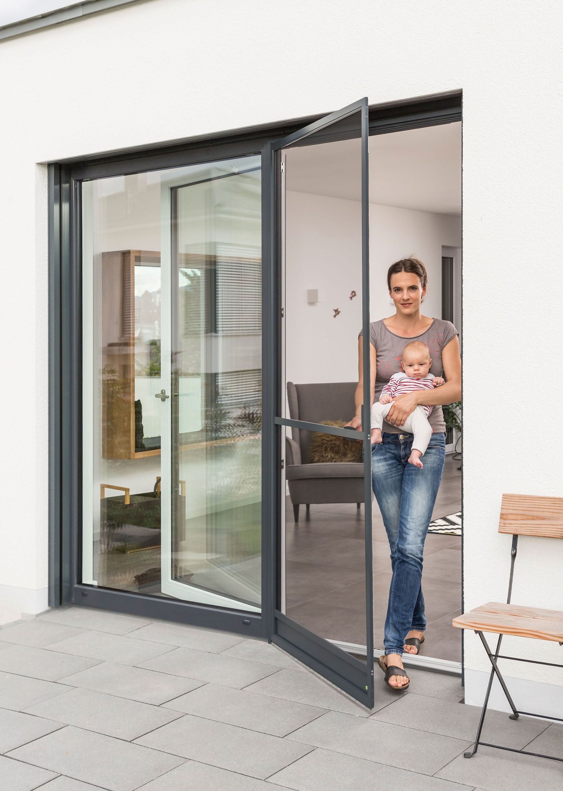 Eine Frau hält ein Baby vor einer Glasschiebetür.