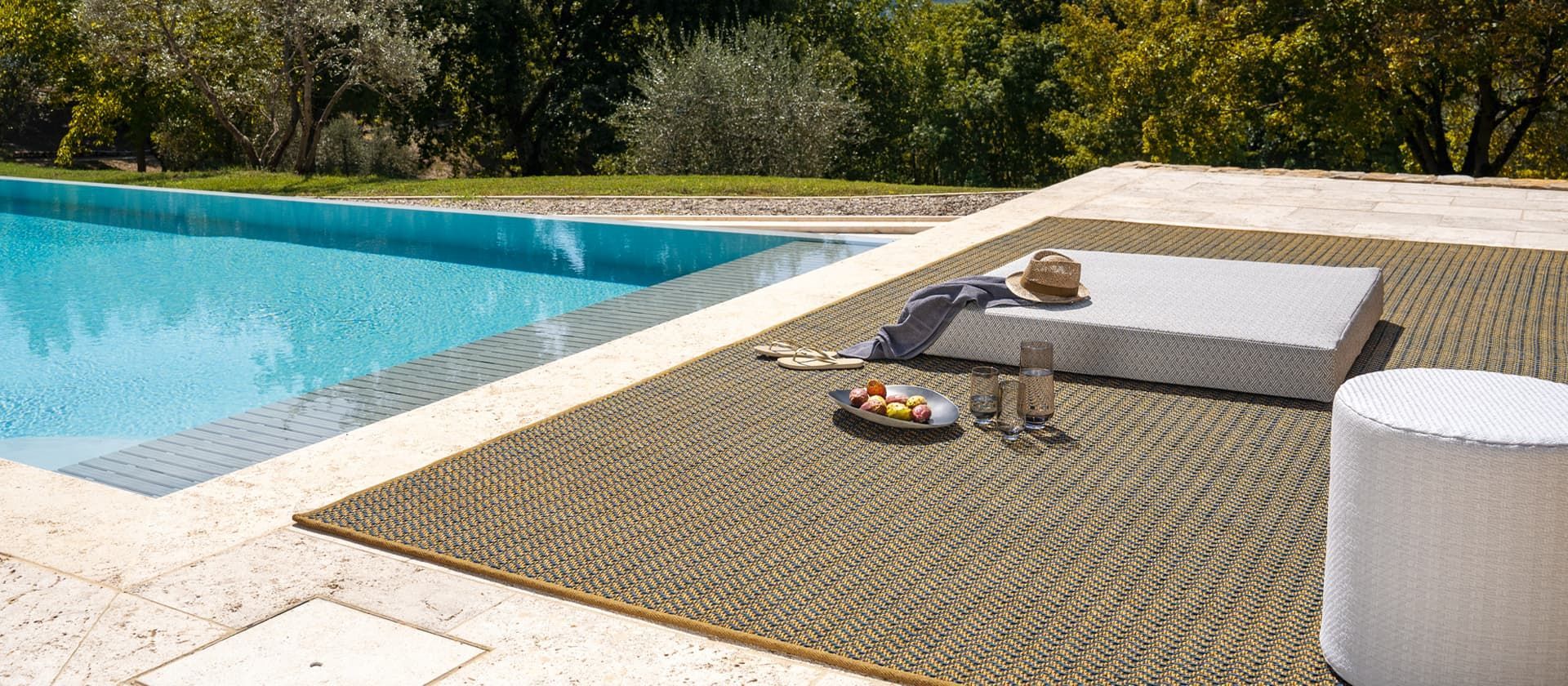 Ein Schwimmbecken mit einem Teppich an der Seite