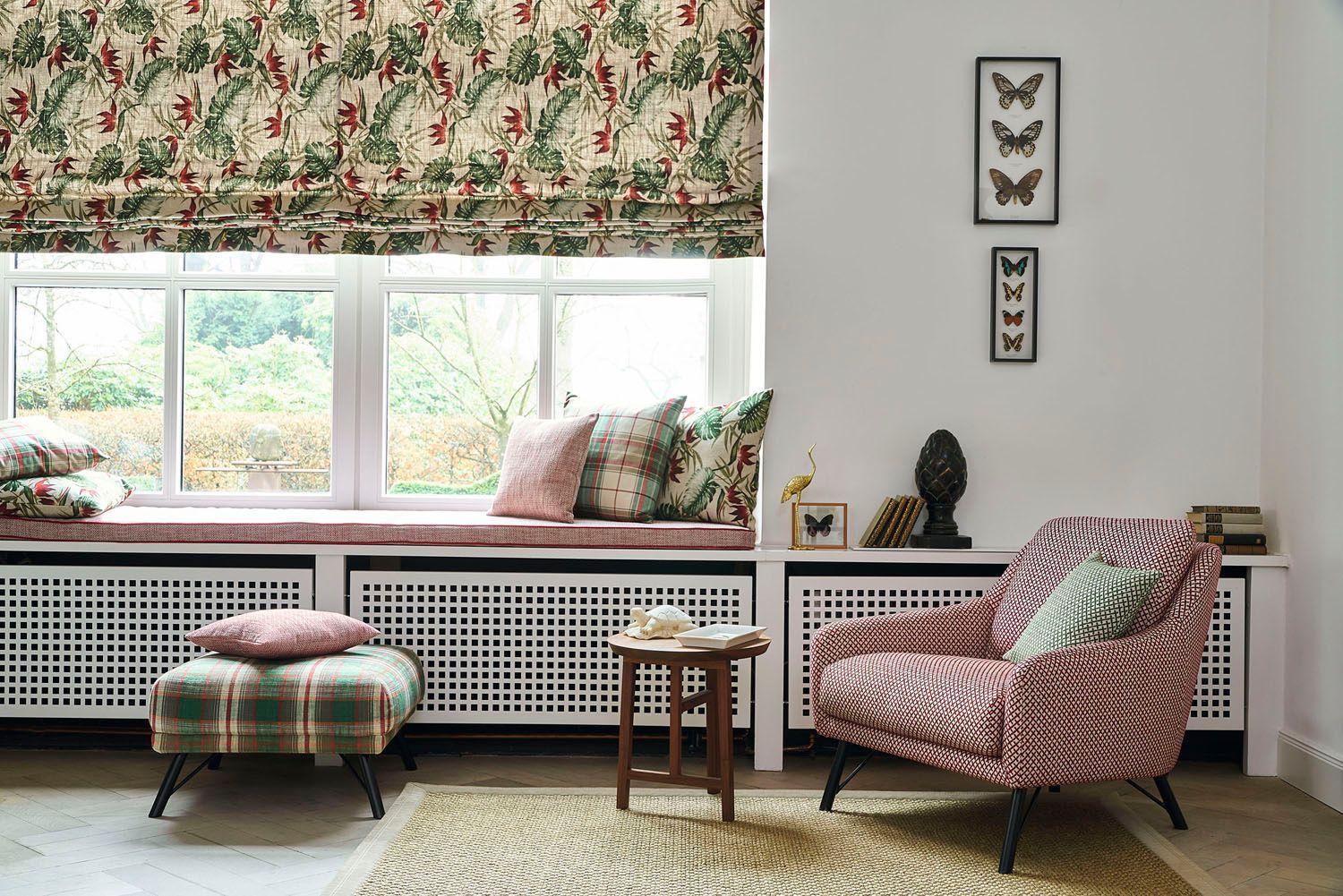 Ein Wohnzimmer mit Sessel, Ottomane und Fenstersitz.