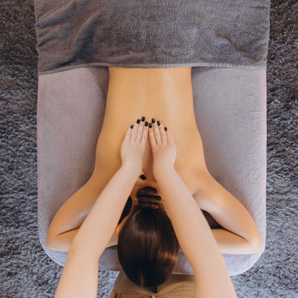 Une personne reçoit un massage du dos sur une table de massage.