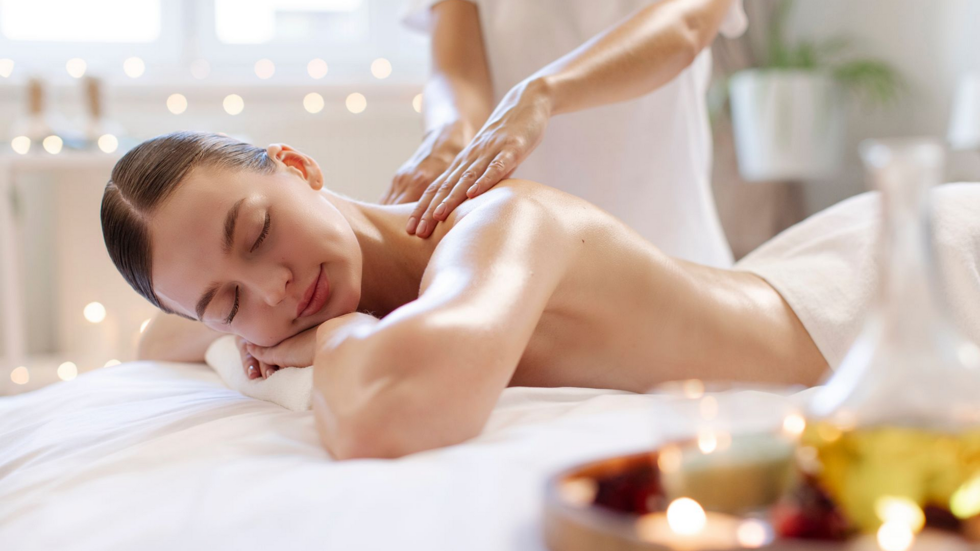 Une femme reçoit un massage des épaules dans un spa allongé sur une table de massage