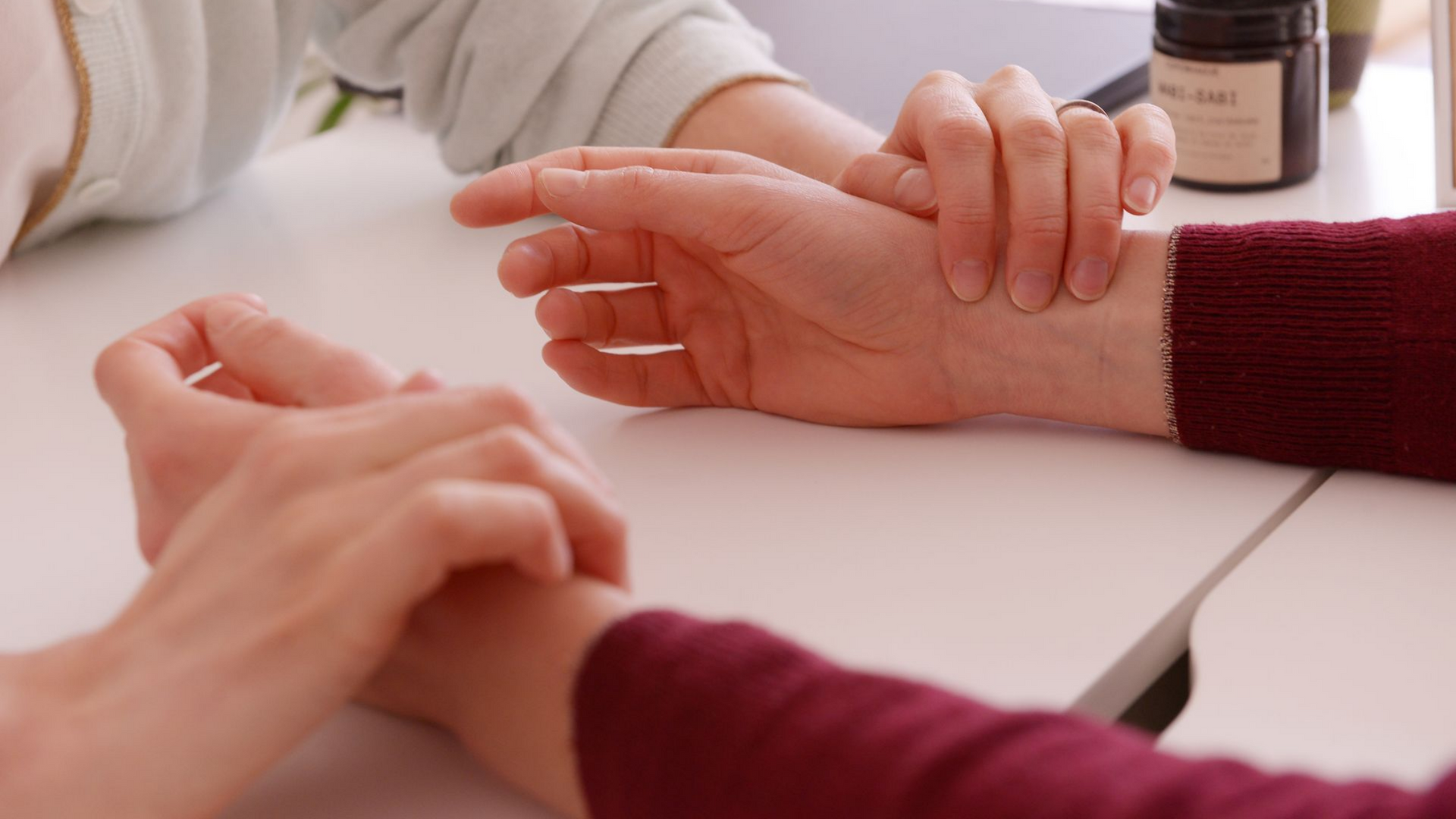 Deux paires de mains vérifient le pouls aux poignets. 