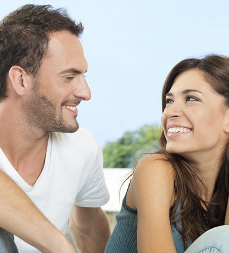 Un hombre y una mujer se miran y sonríen.