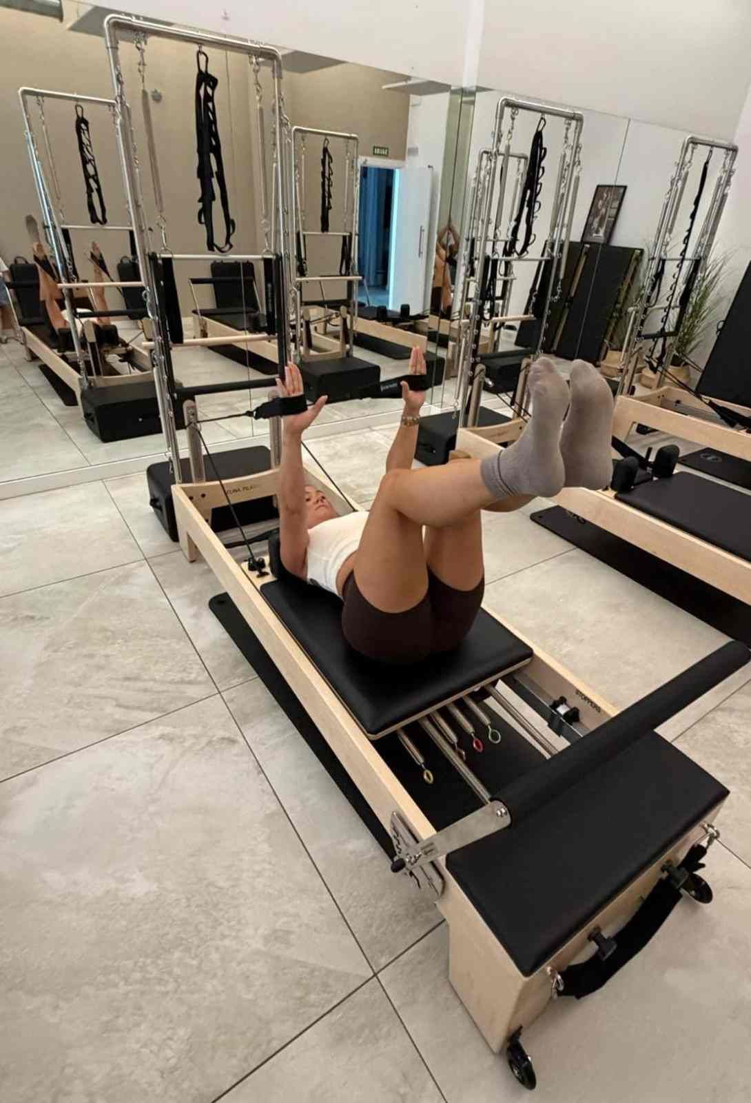 Estudio de pilates cubierto, con máquinas reformer dispuestas en filas bajo una iluminación cenital brillante
