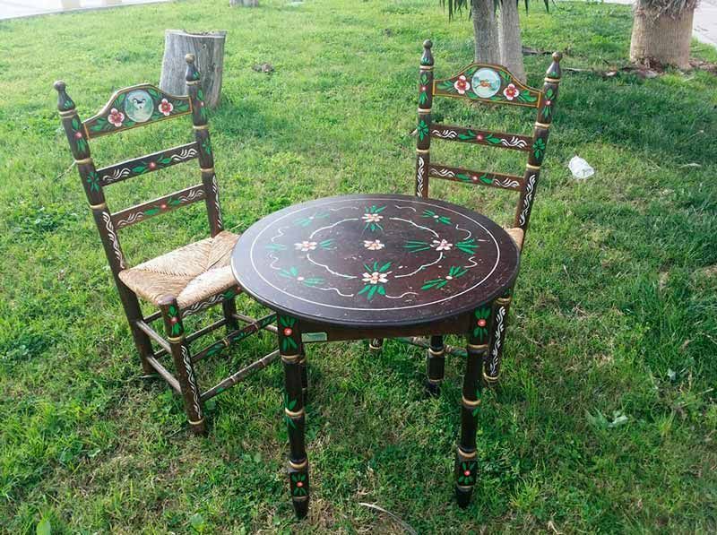 Una mesa y sillas están colocadas encima de un exuberante campo verde.