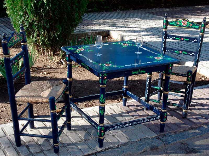 Una mesa azul con dos copas de vino encima.