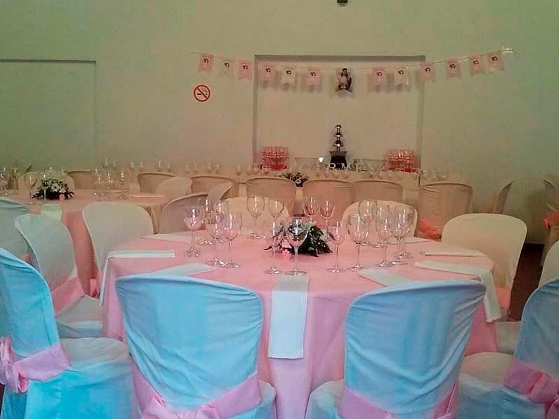 Una sala con mesas y sillas preparadas para una recepción de boda.