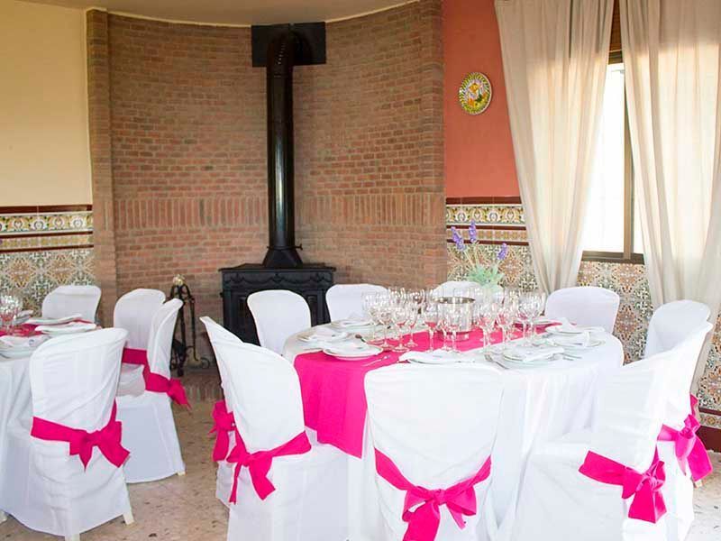 Una sala con mesas y sillas preparadas para una recepción de boda.