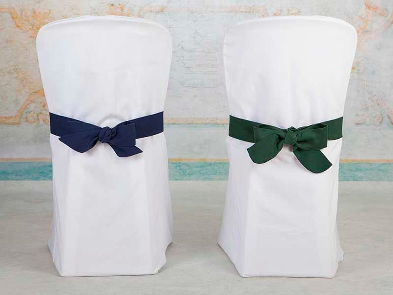 Dos sillas blancas con lazos azules y verdes.