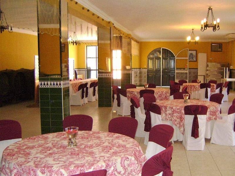 Una gran sala con mesas y sillas preparadas para una fiesta.