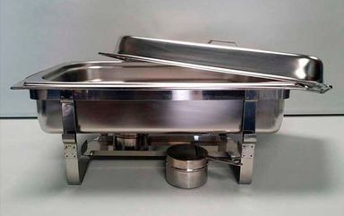 Sobre una mesa hay un plato de acero inoxidable con tapa.