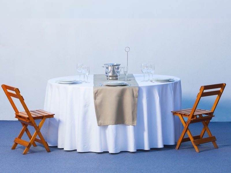 Una mesa con un mantel blanco y dos sillas.