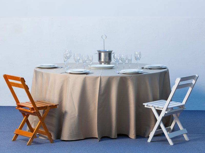 Dos sillas plegables se encuentran junto a una mesa con platos y vasos.