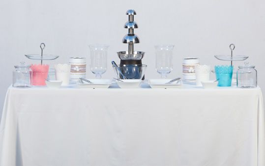 Una mesa con una fuente y vasos encima.