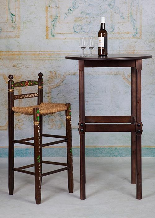 Una botella de vino reposa sobre una mesa junto a una silla.