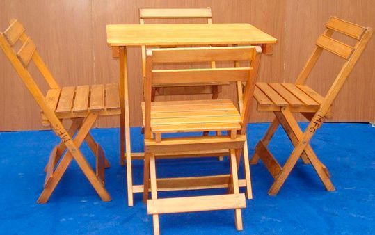 Una mesa y sillas de madera están colocadas sobre una alfombra azul.