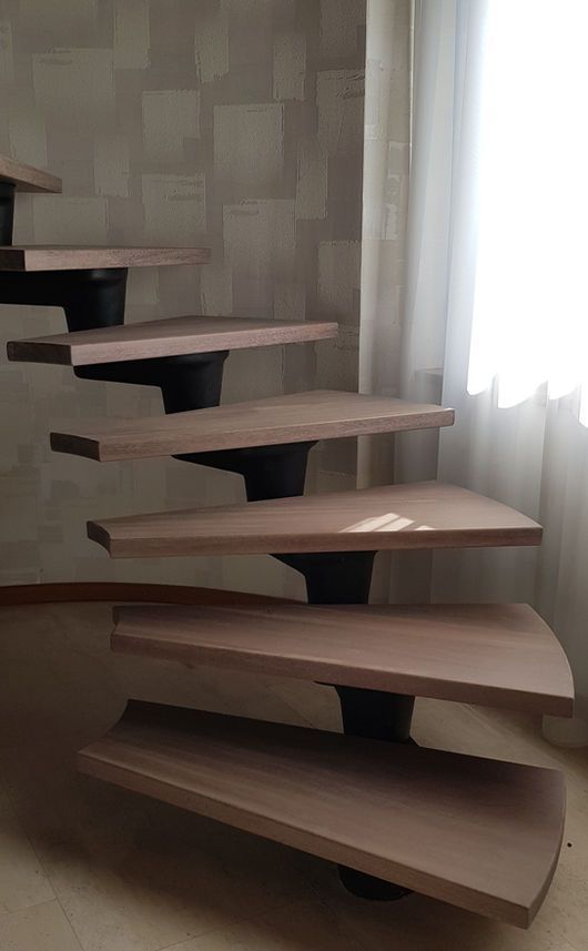 Ein Mann in Latzhose benutzt eine Bohrmaschine, um in einer Küche mit Pflanzen und Werkzeugen einen Schrank zu montieren.