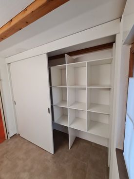 Ein Mann benutzt eine Bohrmaschine, um einen Küchenschrank zu montieren oder zu reparieren.