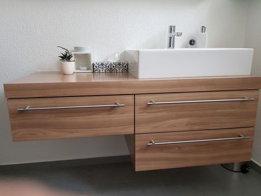 Schwebender Waschtisch aus Holz mit weissem rechteckigem Waschbecken, Chromarmaturen und zwei Schubladen.