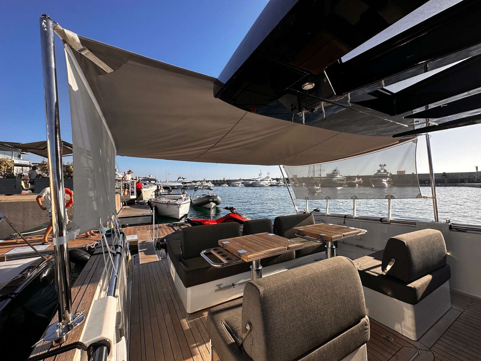 Un barco con mesas y sillas está atracado en el agua.